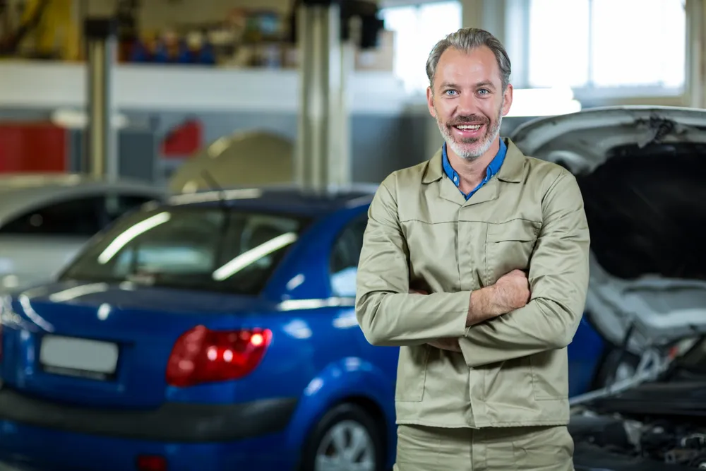 Mechanic inspecting a car engine in a modern garage